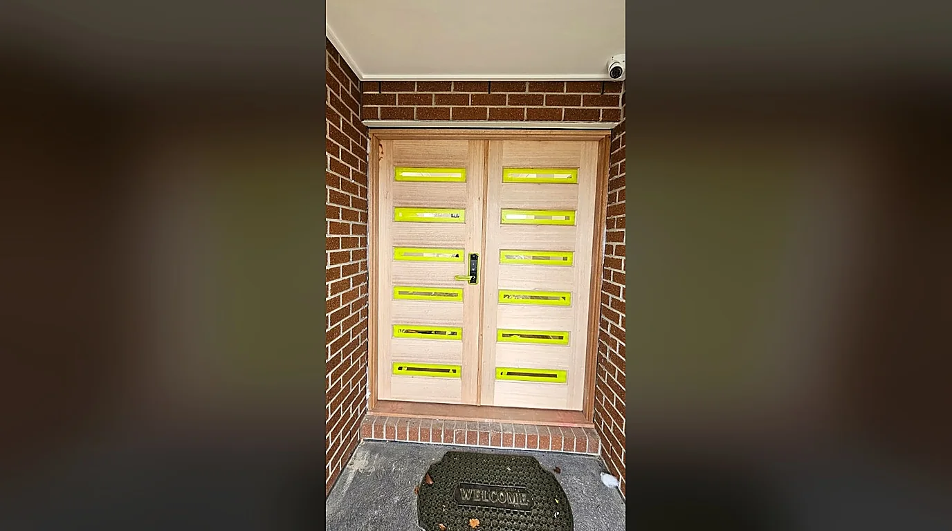 Raw untreated timber doors with masking tape before staining